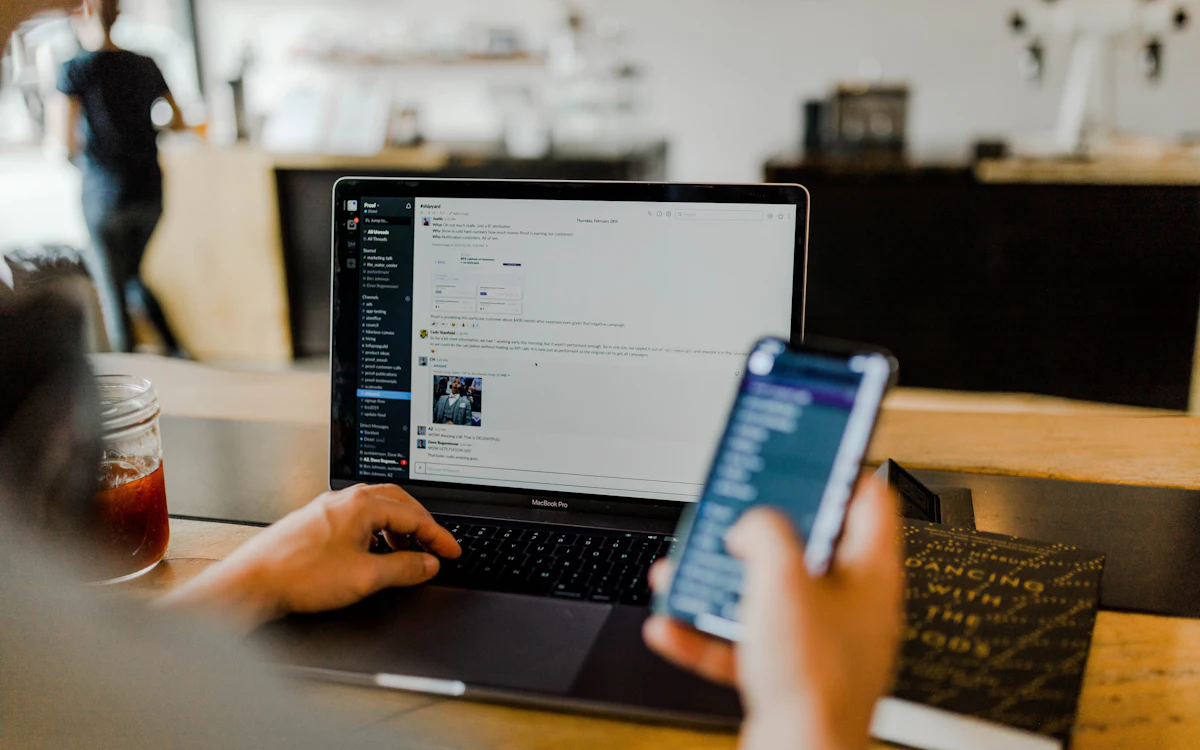 Hands holding a credit card while shopping online on a laptop
