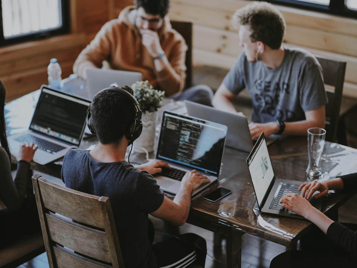 Alphabyte team collaborating around a table with laptops
